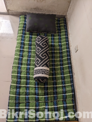 একটি সিঙ্গেল তোশক , কোল বালিশ এবং বালিশ